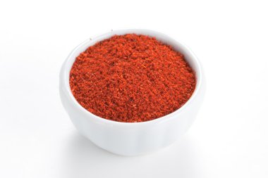 Paprika ground in a white bowl on white background. clipart