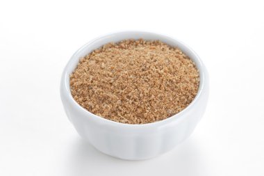 Cumin ground in a white bowl on white background. clipart