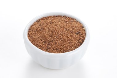 Nutmeg powder (Myristica fragrans) in a white bowl on white back clipart