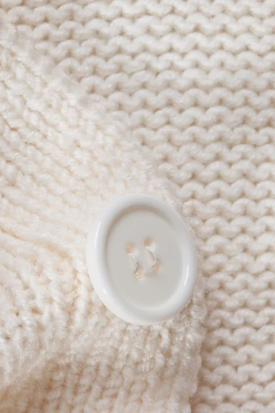 stock image High Resolution knitted texture with a white button background