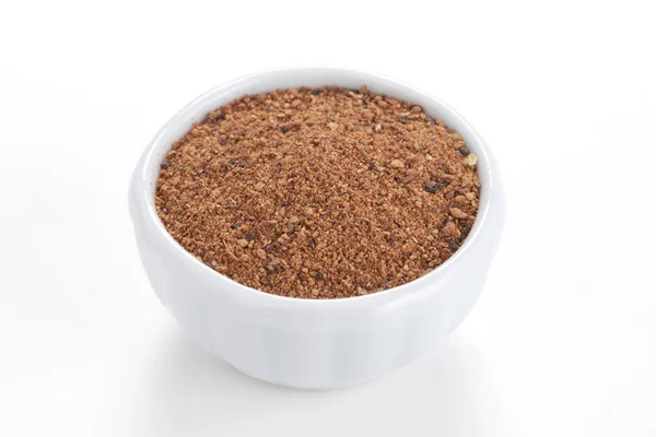 Nutmeg powder (Myristica fragrans) in a white bowl on white back — Stock Photo, Image