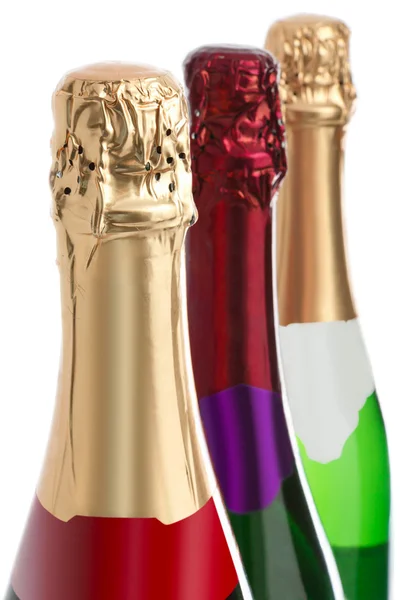 Três garrafas de champanhe em um fundo branco — Fotografia de Stock