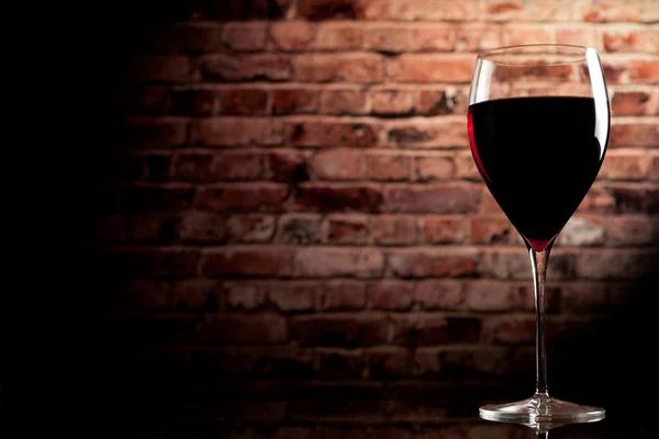 Glas Wein auf dem Hintergrund einer Ziegelmauer — Stockfoto