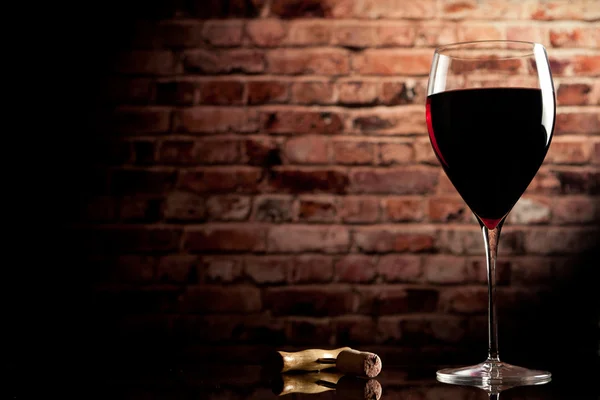 Glass of wine on the background of a brick wall — Stock Photo, Image