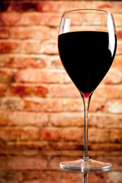 Sklenka vína na pozadí cihlová zeď — Stock fotografie
