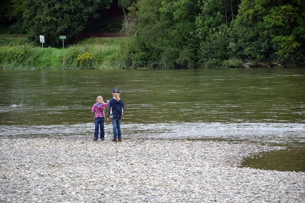 Jongen steen gooien in de rivier — Stockfoto