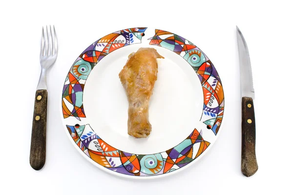 Gamba di pollo arrosto su piatto con forchetta e coltello — Foto Stock