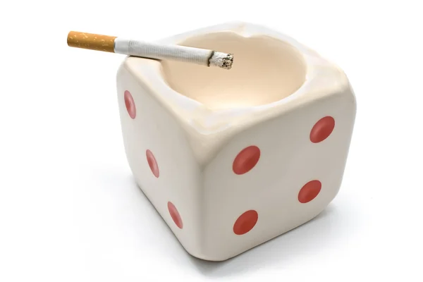Пепельница в форме кубиков с горящей сигаретой — стоковое фото
