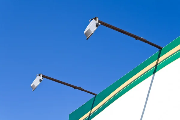 Two spot lights poles on billboard — Stock Photo, Image