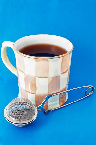 Cup of tea and tea infuser — Stock Photo, Image