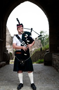 Bagpiper in a mediaval Castle clipart