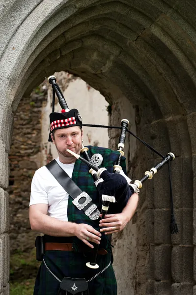 Bagpiper under Archway — Stock Photo, Image