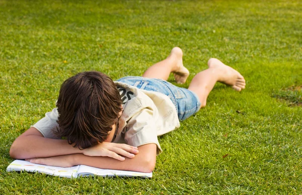 stock image Boy sleeping over boring book