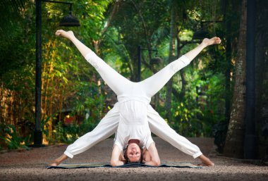 Couple yoga head stand pose clipart