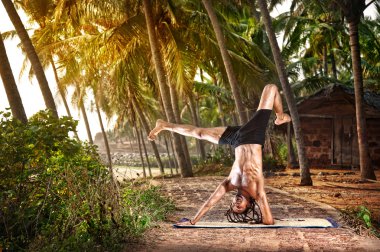 Yoga handstand pose in tropic clipart