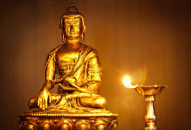 Golden Buddha with oil lamp