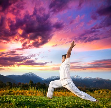 Yoga warrior pose in mountains clipart