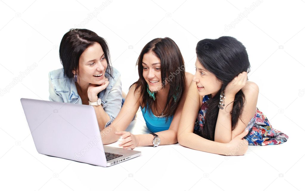Three girls-students with laptop sitting on white background