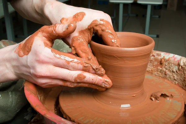 Hands of a potter, creating an earthen jar on the circle — Stock Photo, Image