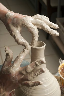 Hands of a potter, creating an earthen jar on the circle clipart