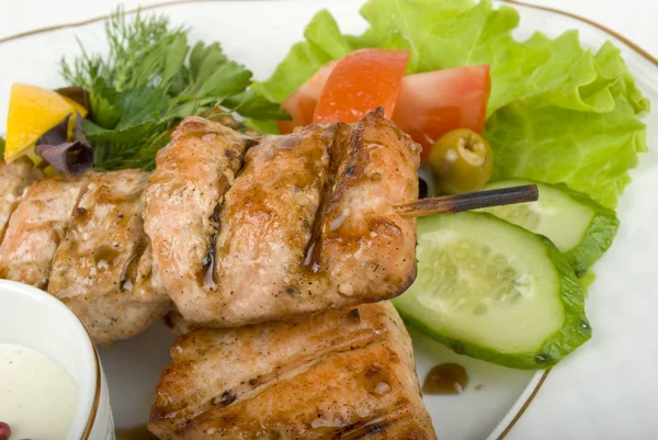 stock image Pork (or chicken) on a grill spit with salad