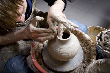 Hands of a potter, creating an earthen jar on the circle clipart