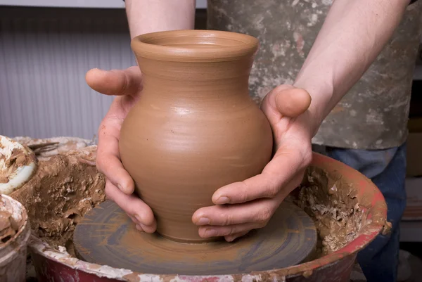 The hands of a potter, creating an earthen jar on the circle — Stock Photo, Image
