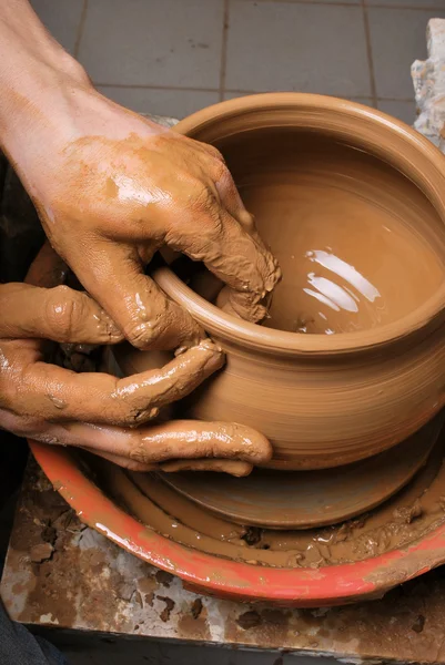 Hands of a potter, creating an earthen jar on the circle — Stock Photo, Image