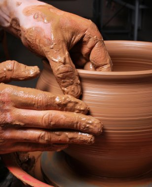 Hands of a potter, creating an earthen jar on the circle clipart