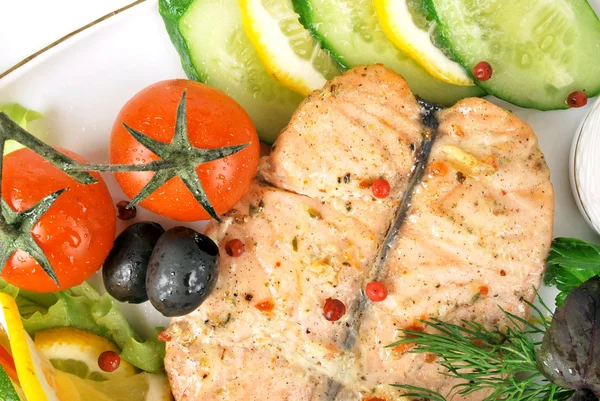 Жареный лосось со спаржей и помидорами черри на белой тарелке — стоковое фото