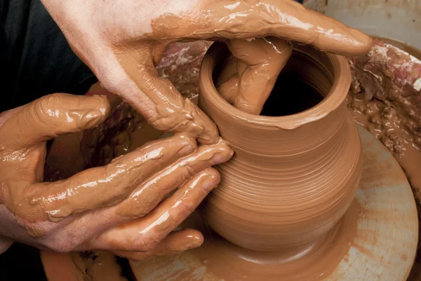 Hands of a potter, creating an earthen jar on the circle — Stock Photo, Image