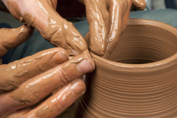 Hands of a potter, creating an earthen jar on the circle — Stock Photo, Image