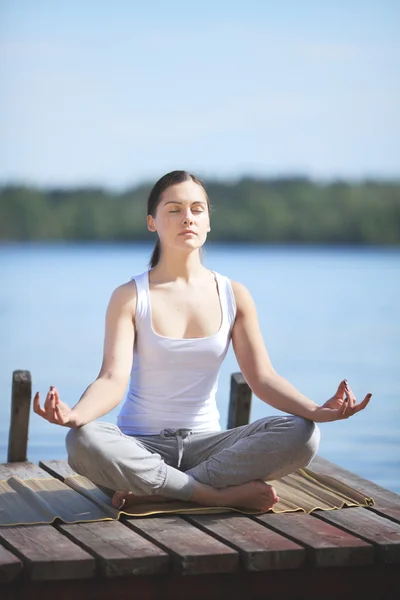 Belle jeune fille formation yoga près d'un lac — Photo