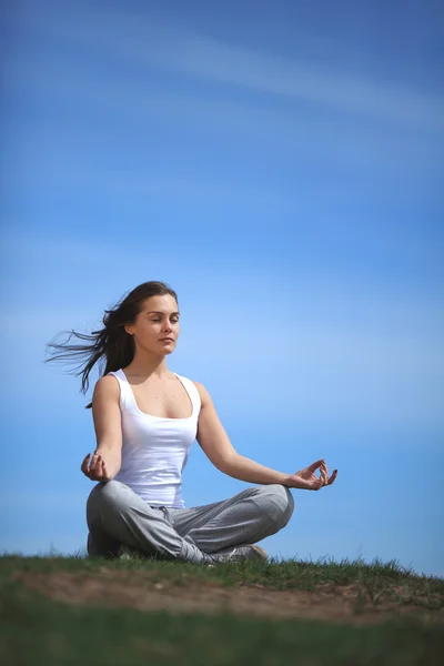 Beautiful young girl training yoga on sunny meadow — Stock Photo, Image