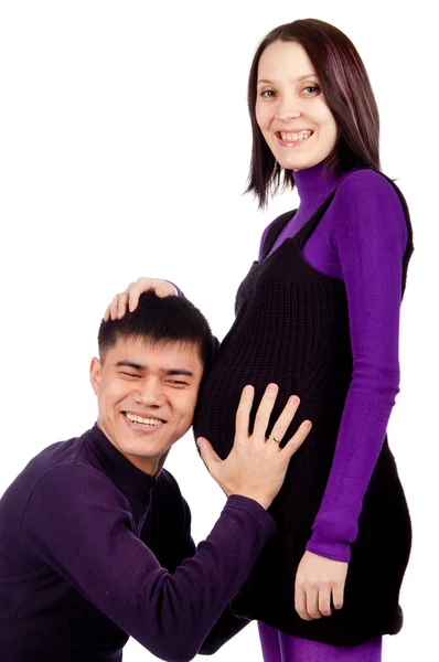 Молода щаслива вагітна пара закохана крупним планом на чорному тлі в студії — стокове фото