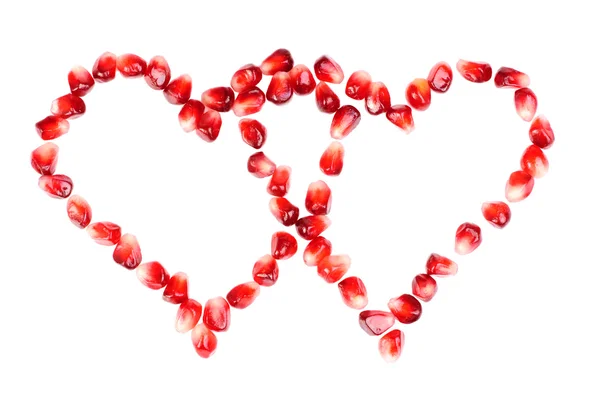 Pomegranate seeds as heart shaped isolated on white — Stock Photo, Image