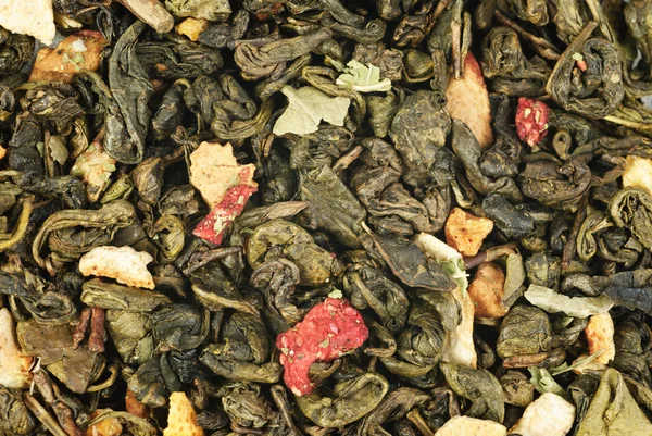 Πράσινο τσάι με φλούδα πορτοκαλιού και της φράουλας ως φόντο — Φωτογραφία Αρχείου