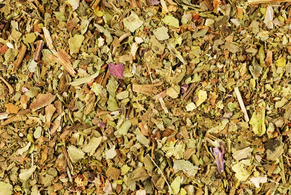 Mucchio di basilico essiccato macinato (Basilico Dolce) come sfondo. Utilizzato come spezia in erbe culinarie in tutto il mondo. La pianta è utilizzata anche in medicina . — Foto Stock