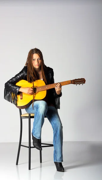 Ragazza in giacca nera e jeans blu con chitarra — Foto Stock