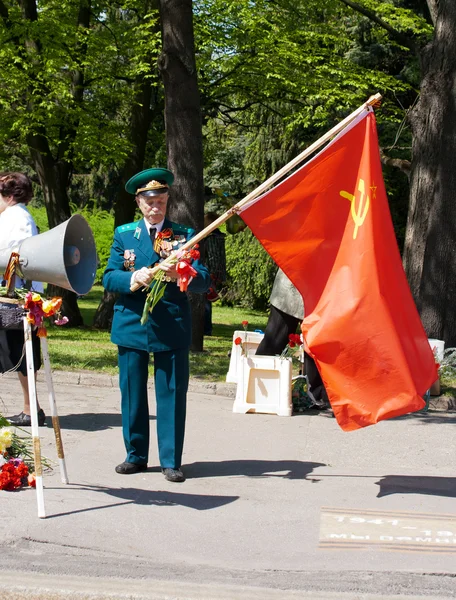 Oude veteraan met rode vlag op dag van de overwinning — Stockfoto