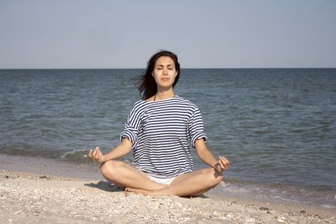 Dışarıda yoga yapan genç bir kadın.