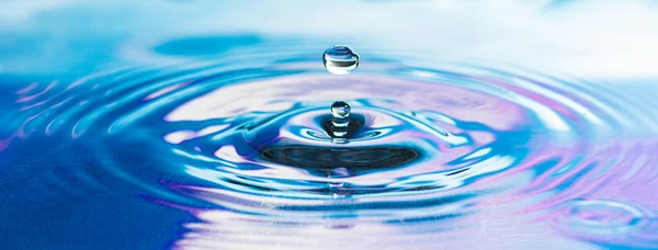 Gota de agua dulce pura cae en el agua Imagen de stock