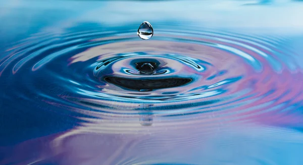 Капля чистой пресной воды падает в воду Стоковое Фото