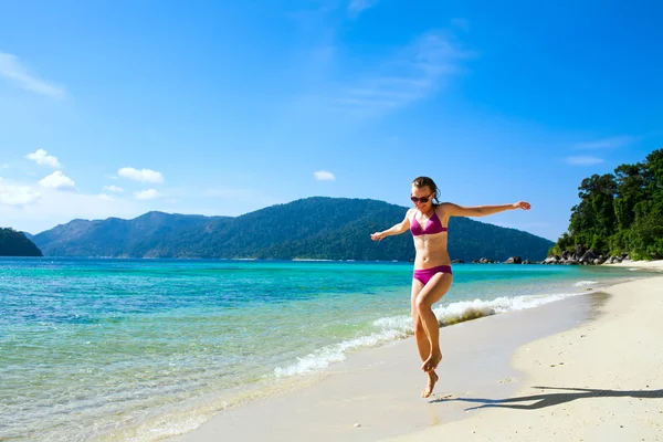 Vrouw loopt langs tropisch eiland strand — Stockfoto