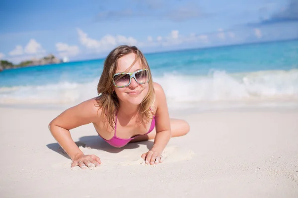 Ευτυχισμένη γυναίκα που αναπαύεται στην παραλία — Φωτογραφία Αρχείου