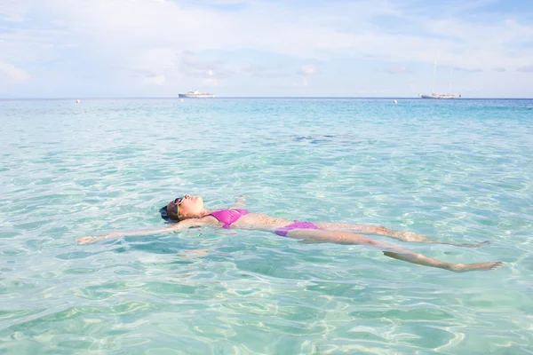 Mujer flotando en agua cristalina —  Fotos de Stock
