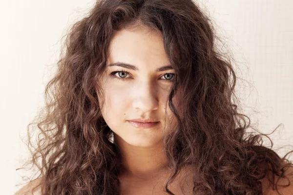 Portrait of a beautiful young brunette with curly hair — Stock Photo, Image