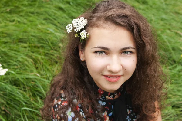 Porträt einer schönen jungen Brünetten mit blühenden Zweigen — Stockfoto