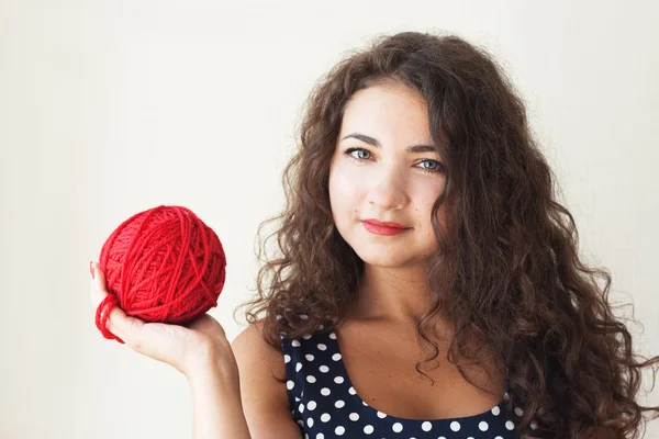 A beautiful young brunette with a ball of thread in their hands — Stock Photo, Image