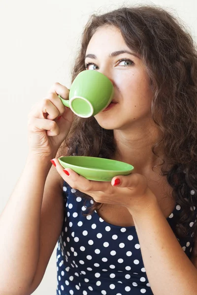 Beautiful young brunette holding a cup — Stock Photo, Image